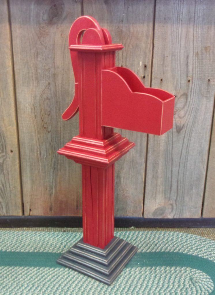 wooden hand pump painted red with gray base